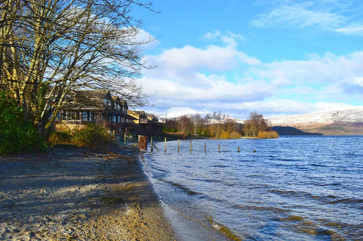 The shore of Loch Lomond with snow on the hills
